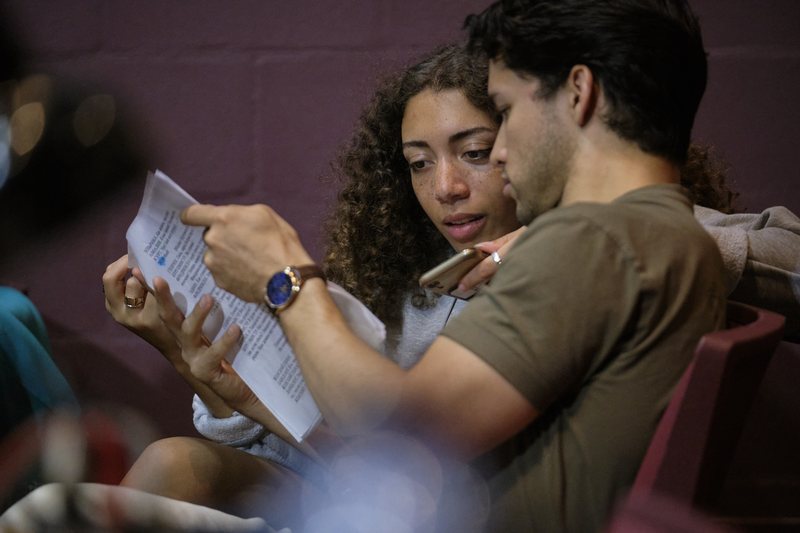 Emmanuel Colmenares and a classmate reading a Russian-language play script together in a theater, Middlebury Russian School, summer 2023.